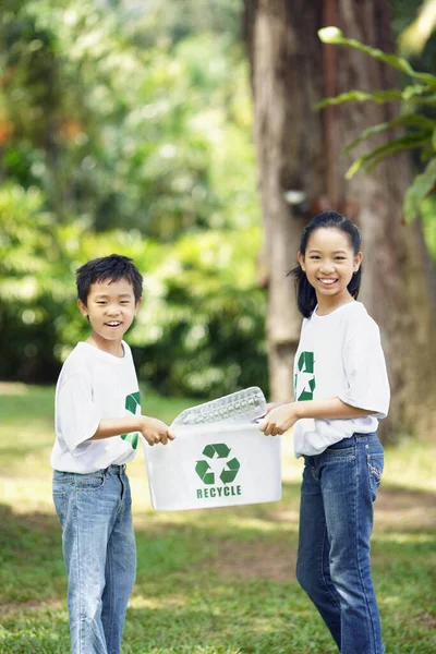 リサイクルビンを運ぶ男の子と女の子 — ストック写真