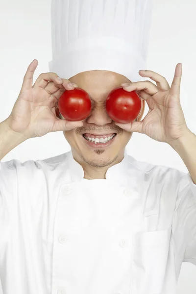 Chef Asiático Segurando Tomates Frente Dos Olhos — Fotografia de Stock