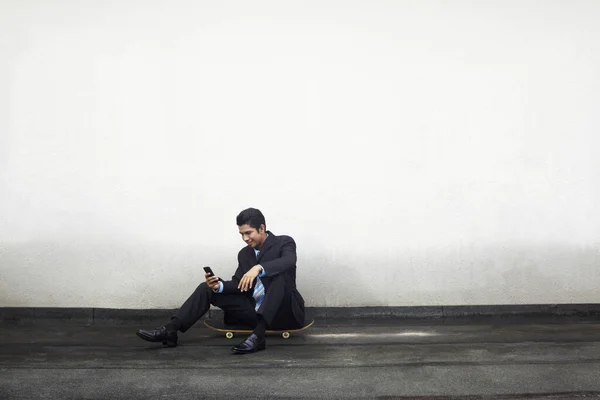 Ung Affärsman Sitter Skateboard Sms Telefon — Stockfoto