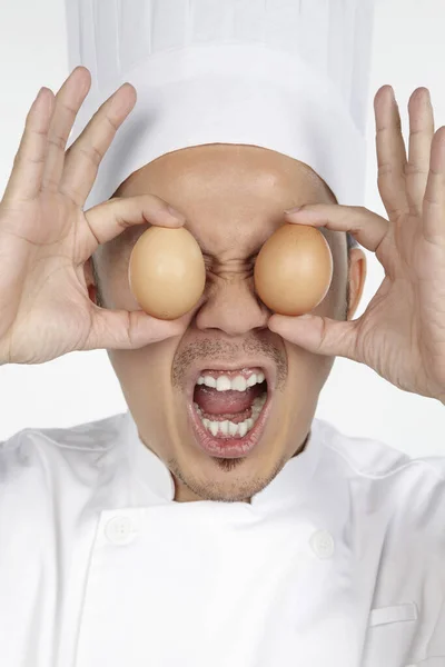 Asiático Chef Segurando Ovos Frente Dos Olhos Com Expressão Facial — Fotografia de Stock