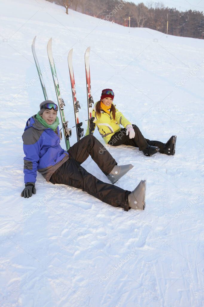 Man and woman resting after skiing