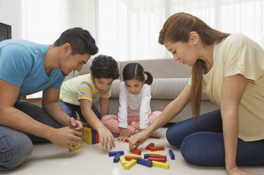 Dört kişilik aile yapı taşlarıyla oynuyor.