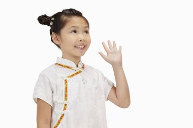 Cheongsam 'lı kız gülümsüyor ve elini kaldırıyor.
