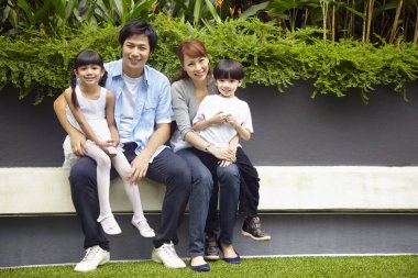 Aile dışarıda birlikte oturuyor.