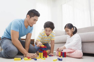 Neşeli baba çocuklarıyla oynuyor.