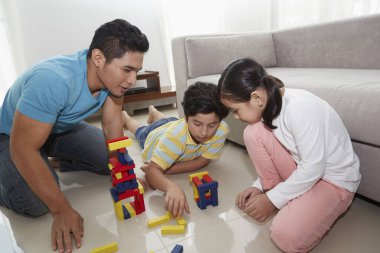 Neşeli baba çocuklarıyla oynuyor.