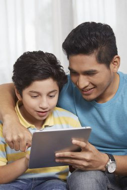 Baba ve oğul birlikte dijital tablet kullanıyorlar.