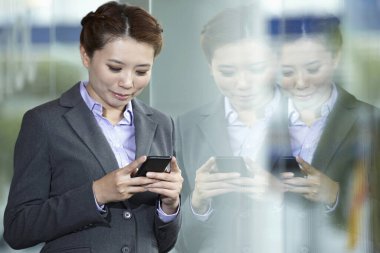 İş kadını akıllı telefondan mesaj atıyor