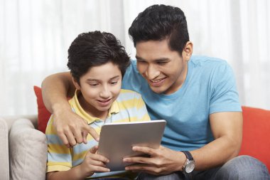 Baba ve oğul birlikte dijital tablet kullanıyorlar.