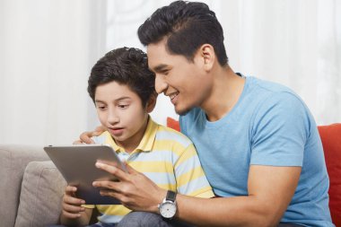 Baba ve oğul birlikte dijital tablet kullanıyorlar.