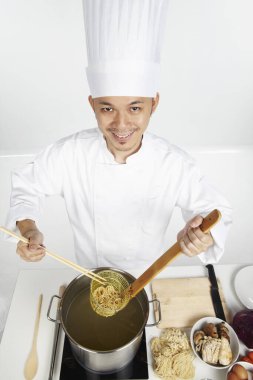 Asyalı şef sağlıklı bir yemek hazırlıyor.