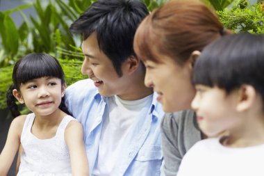 Aile dışarıda birlikte oturuyor.