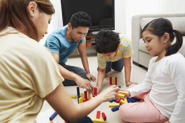 Dört kişilik aile yapı taşlarıyla oynuyor.