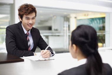 Satış temsilcisi tezgahtaki bir müşteriyle iletişim kuruyor