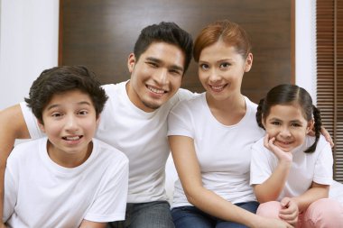 Dört kişilik aile kameraya gülümsüyor.