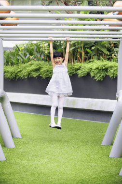 Maymun parmaklıklarında asılı kız