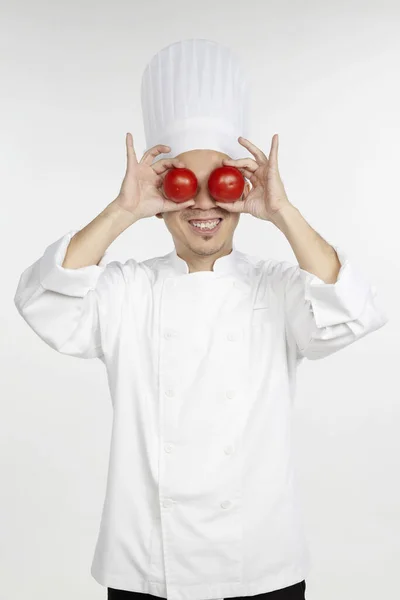 Chef Asiático Segurando Tomates Frente Dos Olhos — Fotografia de Stock