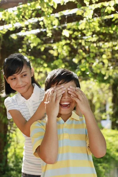 Dívka Zakrývající Chlapcovy Oči Rukama — Stock fotografie