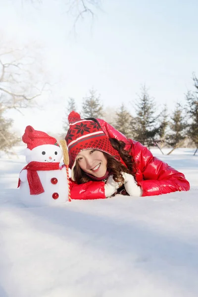 Frau Warmer Kleidung Liegt Mit Schneemann Auf Schnee — Stockfoto