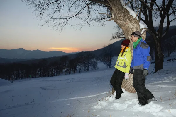 Erkek ve kadın ağaca yaslanıyor