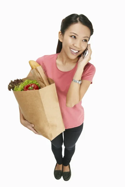 Žena Mluví Telefonu Zatímco Nese Potraviny — Stock fotografie
