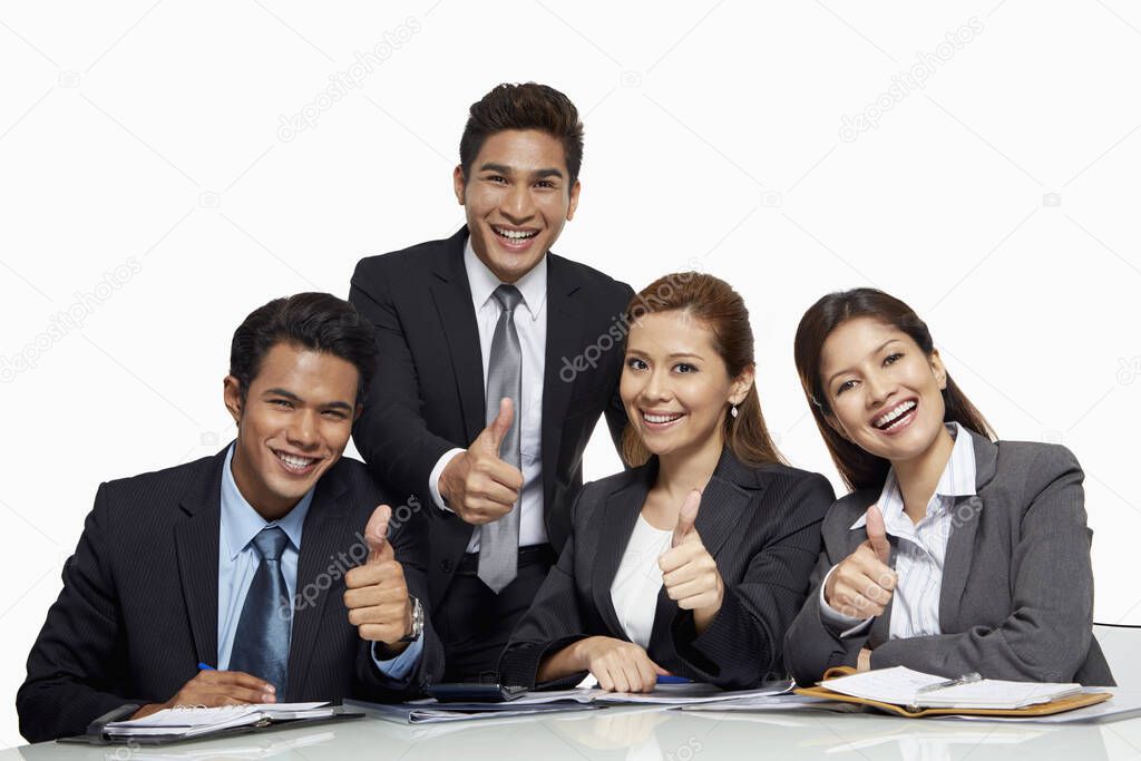 Businessmen and businesswomen giving thumbs up