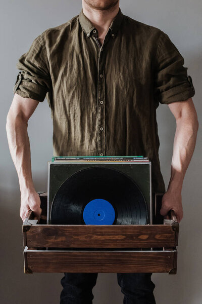 a man holds a box of records