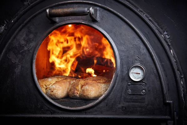 baking whole wheat bread in a wood oven, two freshly baked bread in a bakery with a traditional oven, the process of baking bread, copy space