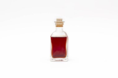 Kırmızı içecek beyaz arka planda eski şişede.