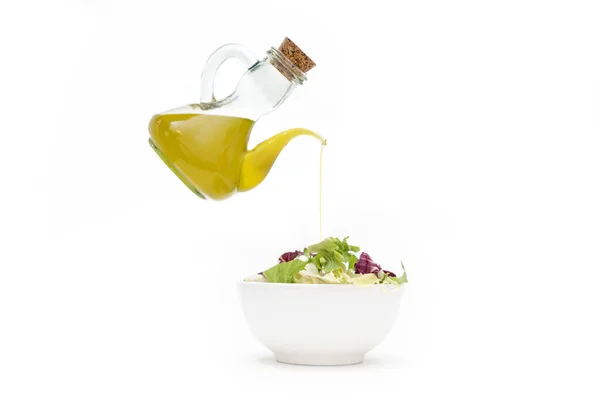 Beyaz arka planda salatada yağ servis eden zeytin ağacı.