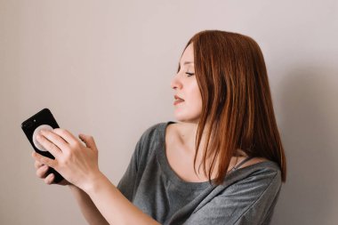 Telefonunu silen ya da temizleyen kadın. Kapatın. Coronavirus konsepti