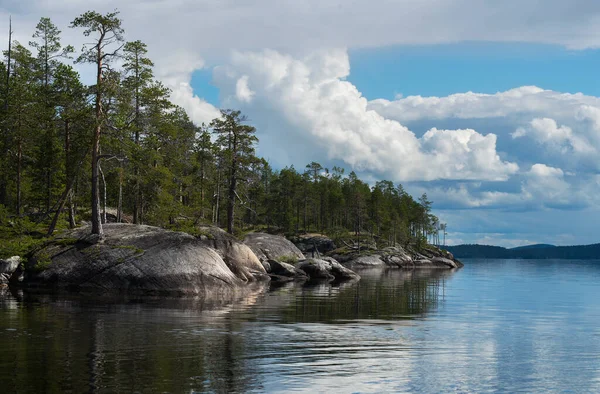 North Karelia lake, Russian wild nature. Forest growing on the stones.  Rock shore of a lake. Scandinavian landscape. Cliff over the water. Scandinavian lakes photo