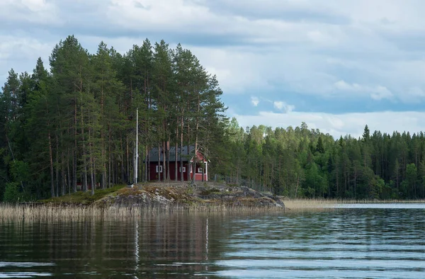 North Karelia lake, Russian wild nature. Forest growing on the stones.  Rock shore of a lake. Scandinavian landscape. Cliff over the water. Scandinavian lakes photo Lonely typical scandinavian house on the lake shore,