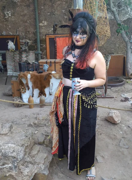 person disguised as a medieval character, at a medieval fair, with makeup and historical adaptation