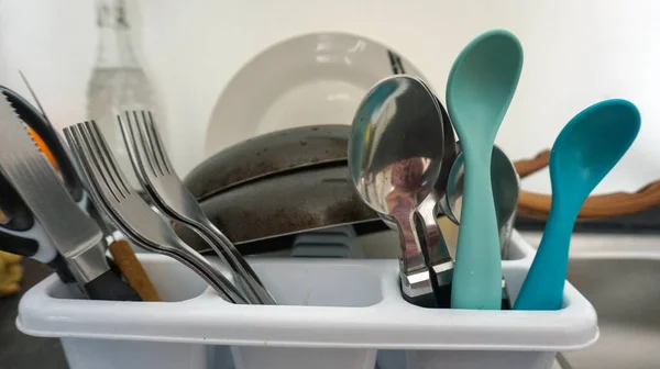 sink with pans dishes and spoons in the kitchen