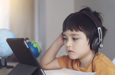 Ödevi için tablet kullanan çocuk izolasyonu, internetteki dijital tablet arama bilgilerini kullanarak covid 19 tecrit, evde eğitim, sosyal mesafe, E-öğrenim çevrimiçi eğitim