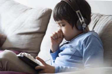 Ödevi için tablet kullanan çocuk izolasyonu, internetteki dijital tablet arama bilgilerini kullanarak covid kilitleme, evde eğitim, sosyal mesafe, E-öğrenme çevrimiçi eğitim