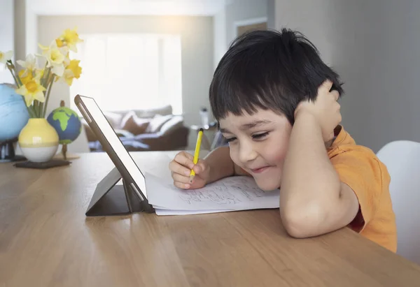 幸せな子供はタブレット上で漫画を見て楽しみを持っています 彼の絵の宿題のためのインターネット上のアイデアを検索デジタルパッドを使用して子供 家庭教育 社会的距離 ラーニングオンライン教育 — ストック写真