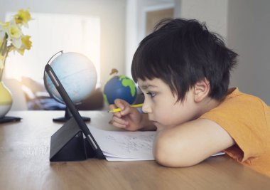 Ödevi için tablet kullanan çocuk izolasyonu, internetteki dijital tablet arama bilgilerini kullanarak covid 19 tecrit, evde eğitim, sosyal mesafe, E-öğrenim çevrimiçi eğitim