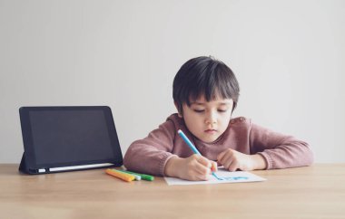 Ödevi için tablet kullanan çocuk izolasyonu, internetteki dijital tablet arama bilgilerini kullanarak covid 19 tecrit, evde eğitim, sosyal mesafe, E-öğrenim çevrimiçi eğitim