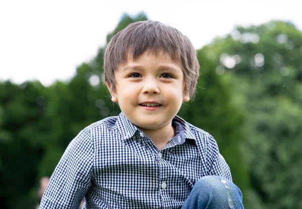 Menino Com Rosto Sorridente Sentado Parque Com Fundo Bokeh Natural — Fotografia de Stock