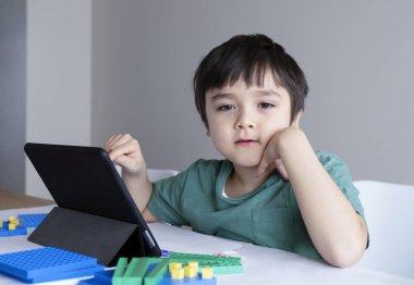 Çocuk evde kalıp Teblet 'te çizgi film izleyecek, çocuk internetteki dijital tableti kullanarak ev ödevi için internetten bilgi arayacak, covid-19 tecrit, sosyal uzaklık, online eğitim...