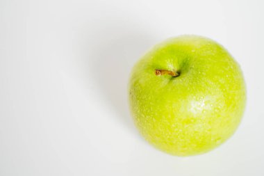 Sade beyaz bir arka planda koca yeşil bir nene elması