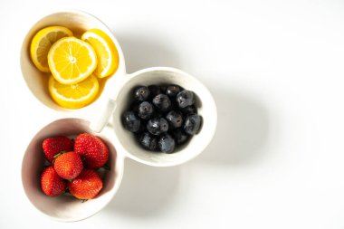 Her bölümde dilimlenmiş limon, çilek ve siyah üzüm servis tabağı.