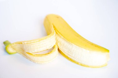 Düz beyaz bir arkaplan üzerinde içi görünen bir muz kabuğu.