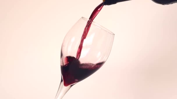 赤ワインを空の涙滴形のワイングラスに入れてゆっくりとした動きで白い背景に — ストック動画