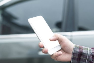 Arabadaki akıllı telefonu kullanarak insan elini kapat.