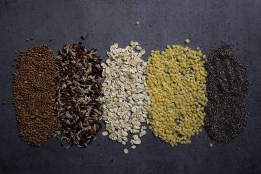 Koyu gri arka planda beş farklı mısır gevreği. Sağlıklı beslenme konsepti. Süper yiyecek üst görünüm fotoğrafı.  