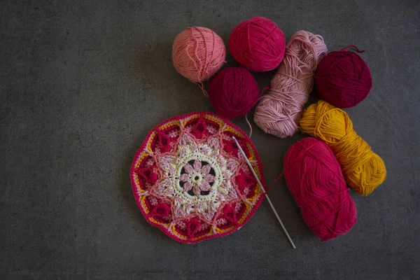 濃い灰色の背景に美しいかぎ針編みのパターンと糸のボール ピンク 赤綿糸トレッド かぎ針編みのフック 趣味だ トップ表示写真 — ストック写真