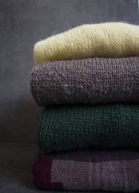 Temiz, yeni yıkanmış, düzgünce katlanmış kadın kışlıkları. Farklı türde kumaşlar. Boşluğu kopyala, kapat, üst görünüm.